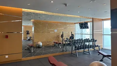 a gym with a lot of equipment in a room at Maison Privee - Refined Studio with Top Facilities in Damac Hills in Dubai