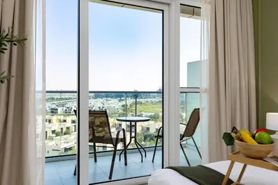 a room with sliding glass doors leading to a balcony at Maison Privee - Refined Studio with Top Facilities in Damac Hills in Dubai