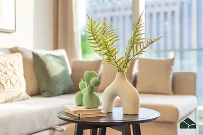 a living room with a couch and a table with cactus at Upgraded 1BR in JW Marriot with Marina View by BMS in Dubai