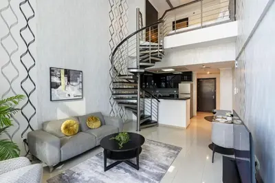 a living room with a couch and a spiral staircase at Urban Haven - Peaceful Sanctuary - City Loft in Dubai