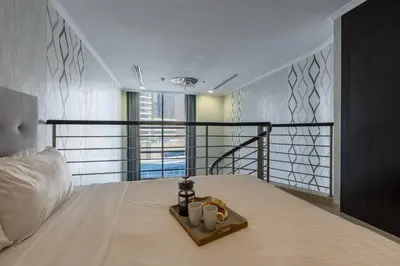 a bedroom with a bed with two candles on it at Urban Haven - Peaceful Sanctuary - City Loft in Dubai