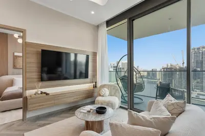 a living room with a tv and a large window at Stylish 2 Bedroom with Panoramic canal View in Dubai