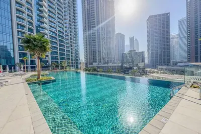 a large swimming pool in a city with tall buildings at Stylish 2 Bedroom with Panoramic canal View in Dubai