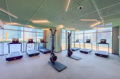 a gym with a bunch of cardio machines in a room at Stylish 2 Bedroom with Panoramic canal View in Dubai