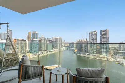 a balcony with chairs and a view of a river at Stylish 2 Bedroom with Panoramic canal View in Dubai