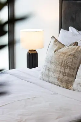 a bedroom with a bed with a lamp on it at Spacious 3BR Villa plus Maids with Resort-Style Amenities in Tilal Al Ghaf in Dubai