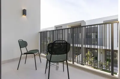two chairs sitting in a room with a balcony at Spacious 3BR Villa plus Maids with Resort-Style Amenities in Tilal Al Ghaf in Dubai
