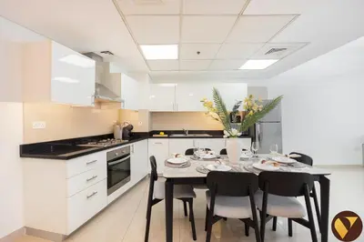 a kitchen with a table and chairs in a kitchen at Vogue DIFC Damac Park Tower near Museum of The Future, One Bedroom Apartment with Balcony, City Skyline and Museum of The Future View, Access to all Amenities in Dubai
