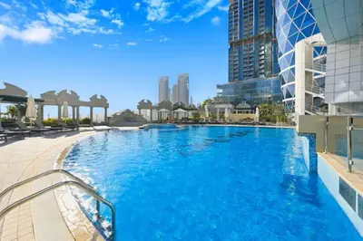 a large blue swimming pool in a city at Vogue DIFC Damac Park Tower near Museum of The Future, One Bedroom Apartment with Balcony, City Skyline and Museum of The Future View, Access to all Amenities in Dubai