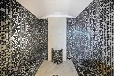 a bathroom with black and white tile walls and benches at Vogue DIFC Damac Park Tower near Museum of The Future, One Bedroom Apartment with Balcony, City Skyline and Museum of The Future View, Access to all Amenities in Dubai