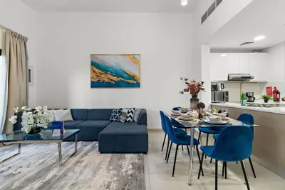 a living room with a blue couch and a table at The Smart Concierge - Andalus Jumeirah Golf Estates in Dubai