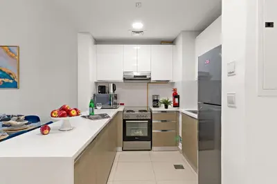 a kitchen with white cabinets and a stove top oven at The Smart Concierge - Andalus Jumeirah Golf Estates in Dubai