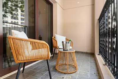 two wicker chairs and a table on a balcony at The Smart Concierge - Andalus Jumeirah Golf Estates in Dubai