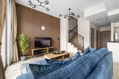 a living room with a large blue couch at Family Retreat 3BR Greenwoods Villa in DAMAC Hills in Dubai