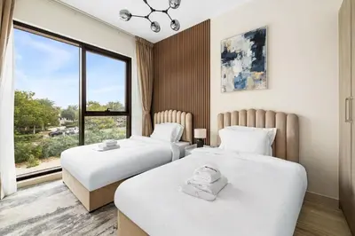 two beds in a room with a window at Family Retreat 3BR Greenwoods Villa in DAMAC Hills in Dubai