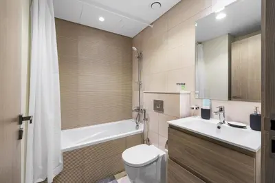 a bathroom with a toilet and a sink and a tub at Family Retreat 3BR Greenwoods Villa in DAMAC Hills in Dubai
