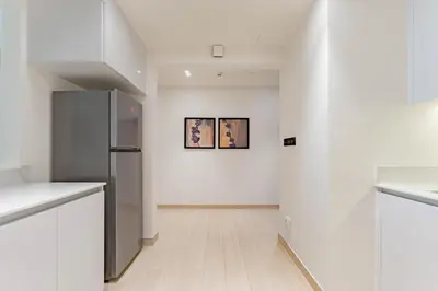 a kitchen with white walls and a refrigerator at HAVN - 3 bedroom in Binghatti Crest, JVC in Dubai