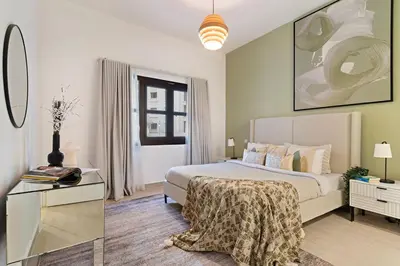 a bedroom with a bed and a table and a window at The Smart Concierge - Andalus Jumeirah Golf Estates in Dubai