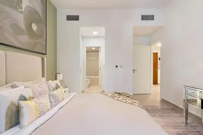a living room with a white couch and a rug at The Smart Concierge - Andalus Jumeirah Golf Estates in Dubai