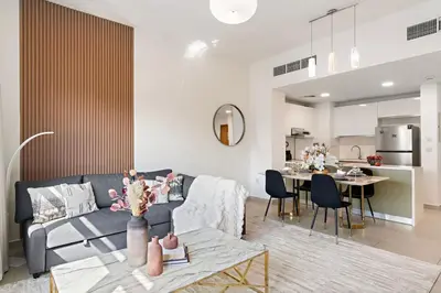a living room with a blue couch and a table at The Smart Concierge - Andalus Jumeirah Golf Estates in Dubai