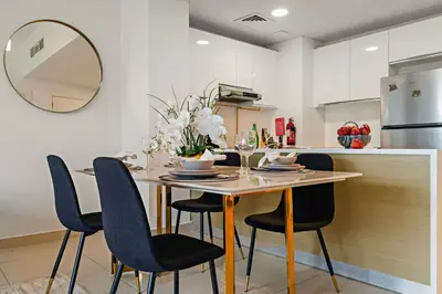a kitchen with a table with chairs and a counter at The Smart Concierge - Andalus Jumeirah Golf Estates in Dubai
