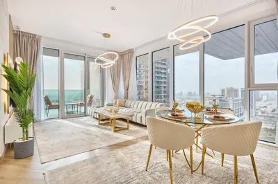 a living room with a couch and a table with chairs at Modern 2BR Apartment with Zabeel Park & Skyline Views in Dubai