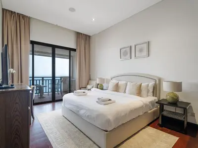 a hotel room with a bed and a balcony at Seaside Serenity 1BR Residence in Royal Amwaj in Dubai