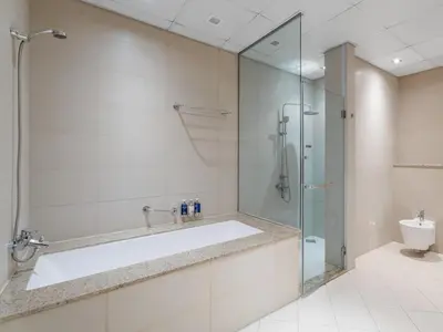 a bathroom with a tub and a glass shower at Seaside Serenity 1BR Residence in Royal Amwaj in Dubai