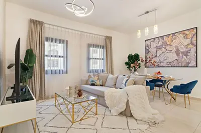 a living room with a couch and a tv at The Smart Concierge - Andalus Jumeirah Golf Estates in Dubai