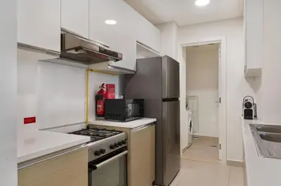 a kitchen with a stove top oven next to a sink at The Smart Concierge - Andalus Jumeirah Golf Estates in Dubai