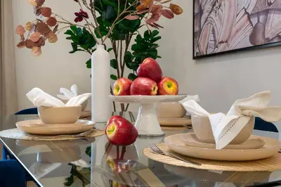a glass table with a plate of apples on it at The Smart Concierge - Andalus Jumeirah Golf Estates in Dubai