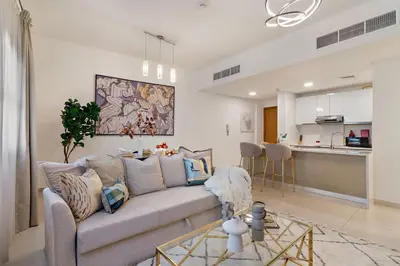 a living room with a couch and a kitchen at The Smart Concierge - Andalus Jumeirah Golf Estates in Dubai