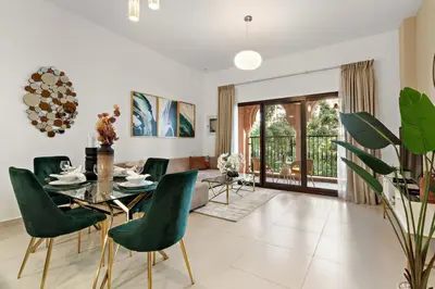 a dining room with a table and green chairs at The Smart Concierge - Andalus Jumeirah Golf Estates in Dubai