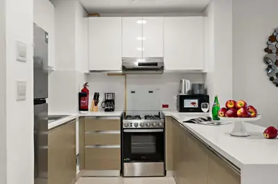 a kitchen with white cabinets and a stove top oven at The Smart Concierge - Andalus Jumeirah Golf Estates in Dubai