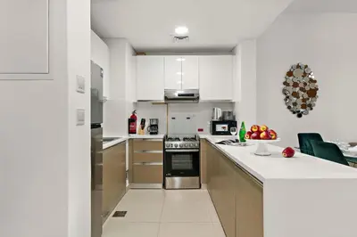 a kitchen with white walls and stainless steel appliances at The Smart Concierge - Andalus Jumeirah Golf Estates in Dubai