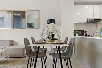 a dining room table with chairs and a kitchen at The Smart Concierge - Andalus Jumeirah Golf Estates in Dubai