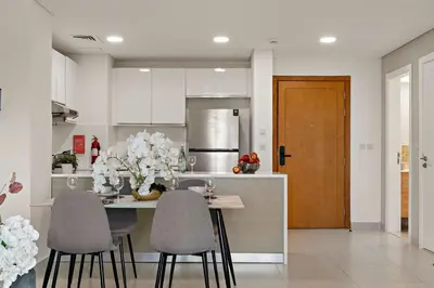 a kitchen with a table and chairs and a refrigerator at The Smart Concierge - Andalus Jumeirah Golf Estates in Dubai