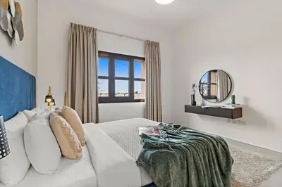 a white bedroom with a bed and a mirror at The Smart Concierge - Andalus Jumeirah Golf Estates in Dubai