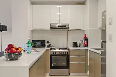 a white kitchen with a bowl of fruit on the counter at The Smart Concierge - Andalus Jumeirah Golf Estates in Dubai