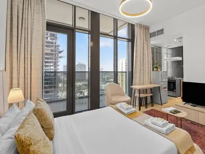 a bedroom with a large bed with a large window at Warm Glow Retreat Cozy Studio In Regina JVC in Dubai
