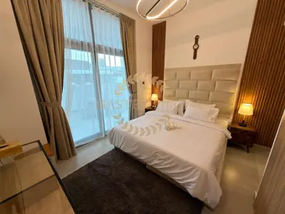 a bedroom with a white bed with a large window at Luxurious Two-Bedroom & Living Room Apartment in Dubai