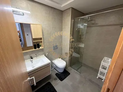 a bathroom with a toilet and a sink and a shower at Luxurious Two-Bedroom & Living Room Apartment in Dubai