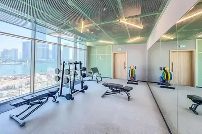 a gym with treadmills and ellipticals in a building at EasyGo - Chic high floor Studio with Burj View in Dubai