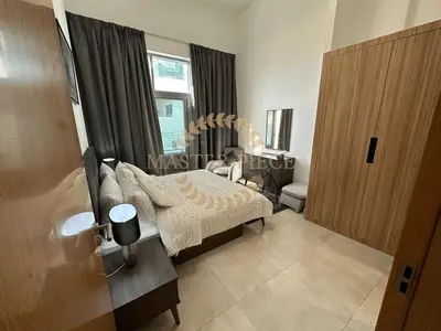 a bedroom with a bed and a chair and a window at Pantheon Elysee in Dubai