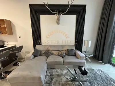 a living room with a couch and a wall with a picture at Pantheon Elysee in Dubai