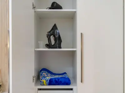 a white closet with a black mask on the shelf at Downtown 4BR Apartment for 12 Guests, Burj and Dubai Mall 5 min in Dubai