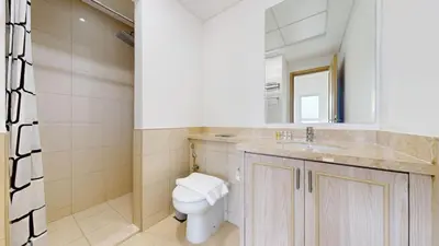 a bathroom with a toilet and a sink and a mirror at Vacationer l Serene 2 Bed Villa l Lush Garden l Family Friendly in Nadd Shubayḩ