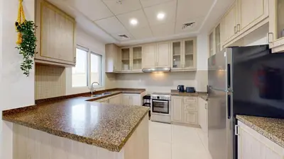 a large kitchen with wooden cabinets and stainless steel appliances at Vacationer l Serene 2 Bed Villa l Lush Garden l Family Friendly in Nadd Shubayḩ