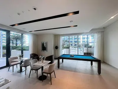 a living room with a pool table and tables and chairs at Vacationer l Modern 1 Bed l Private Beach l Pool, Gym Access in Dubai