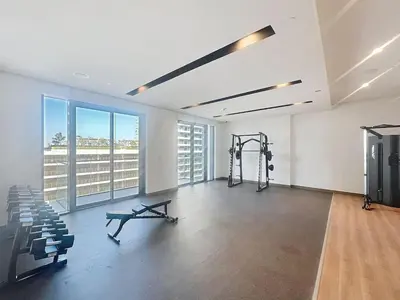 a gym with a treadmill and a bench in a room at Vacationer l Modern 1 Bed l Private Beach l Pool, Gym Access in Dubai